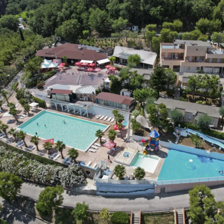 Vista aerea di un resort con piscine, scivoli d'acqua, aree verdi e strutture edilizie.