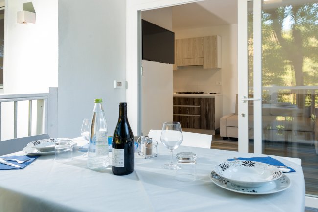 Tavola apparecchiata con vista su cucina moderna.