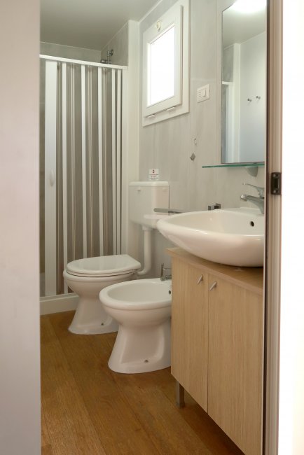Bagno con doccia, lavabo, WC e bidet, arredamento semplice.