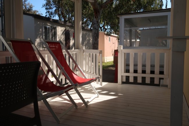 Veranda con due sedie a sdraio rosse.