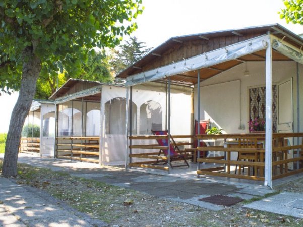 Verande coperte di bungalow con alberi ombreggianti.