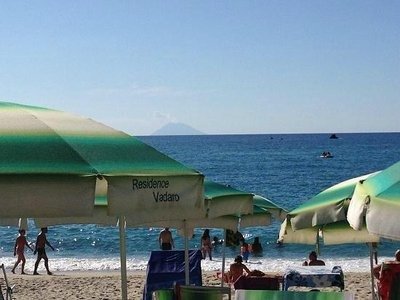 Spiaggia con ombrelloni e persone vicine al mare.
