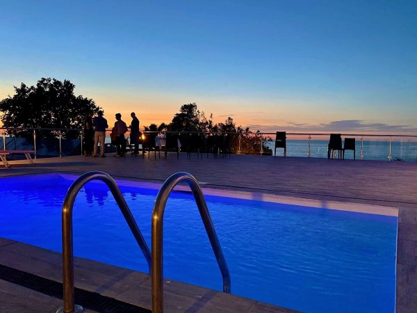 Piscina con vista mare al tramonto.