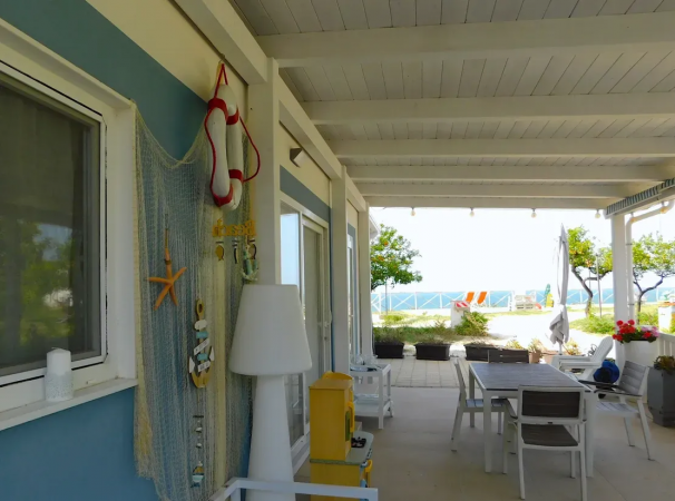 Una terrazza con tavolo da pranzo e decorazioni nautiche.