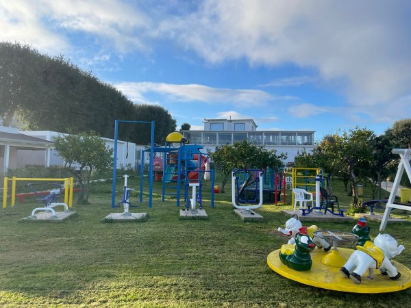 Parco giochi con strutture colorate su prato.