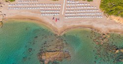 Spiaggia con sdraio e mare turchese.