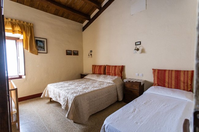 Camera con due letti e arredamento semplice.