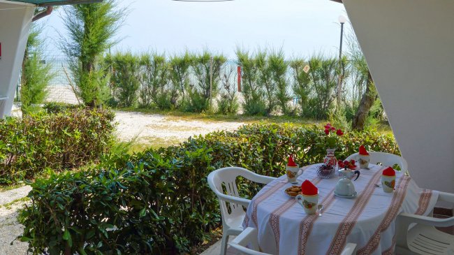 Tavola apparecchiata in un giardino vicino alla spiaggia.