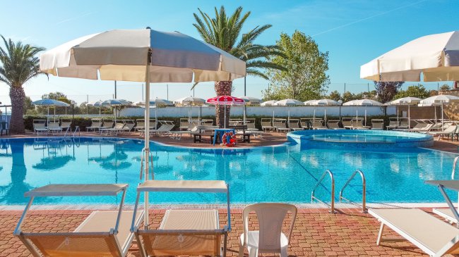 Piscina con lettini e ombrelloni.