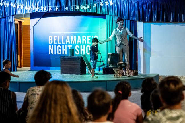 Uomo sul palco con bambino, spettacolo serale.