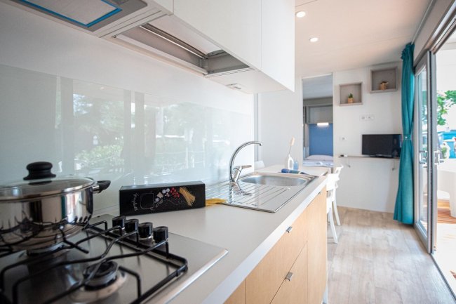 Cucina compatta con fornelli e lavello.