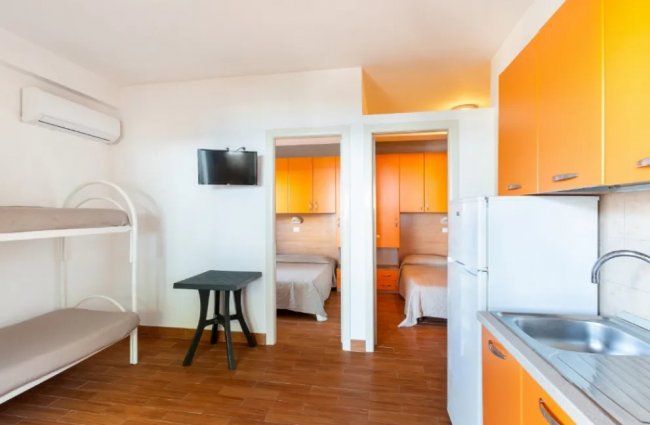 Camera con letti a castello e cucina.