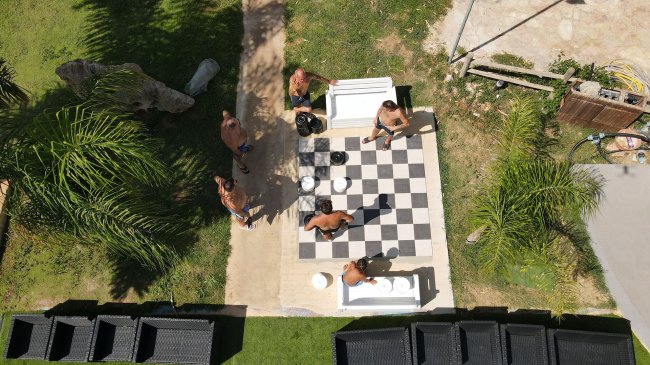 Persone giocano su una scacchiera gigante.