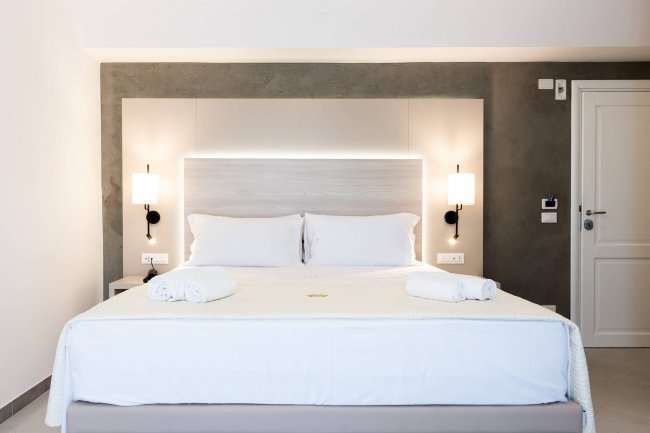 Camera con letto matrimoniale e pareti grigie.