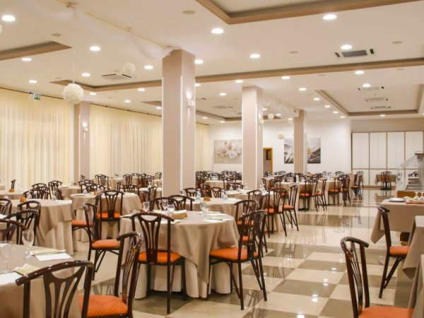 Sala da pranzo formale con molti tavoli.