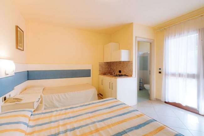 Camera con letto matrimoniale e angolo cottura.
