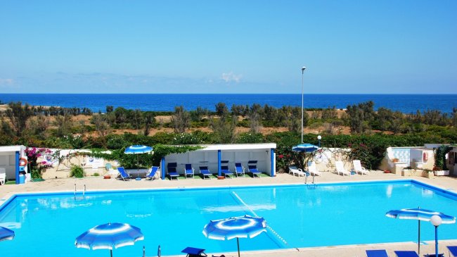 Piscina con vista sul mare e ombrelloni.