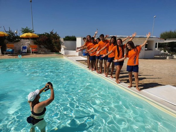 Gruppo in piscina posa per una foto.