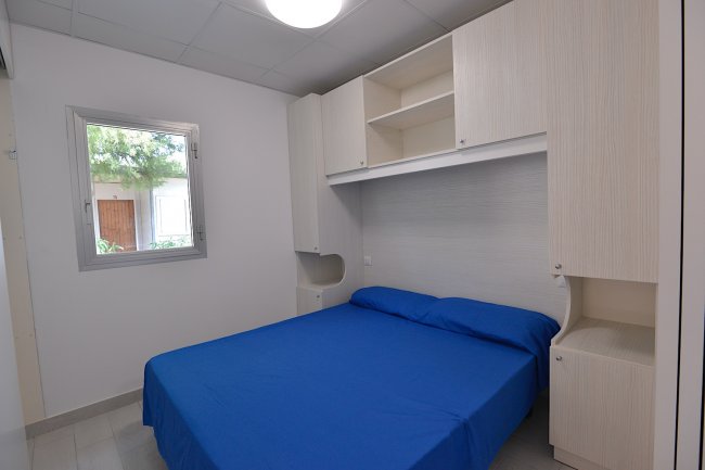 Camera con letto matrimoniale e copriletto blu.