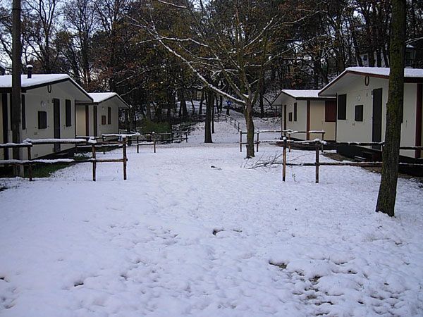 Capanne coperte di neve in un paesaggio invernale.