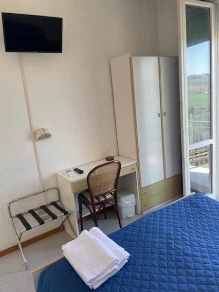 Camera d'albergo con scrivania, televisore e letto.