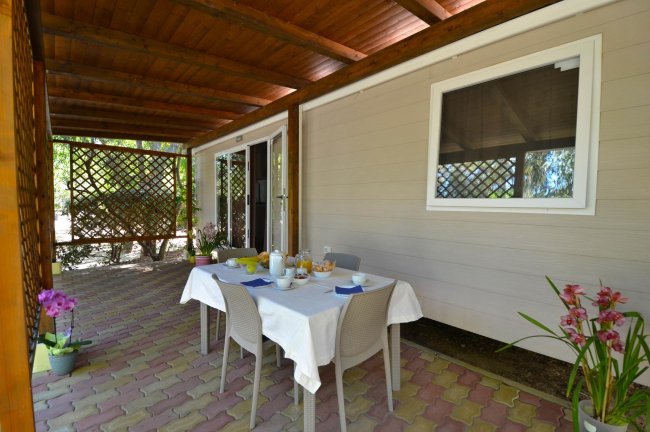 Patio coperto con tavolo apparecchiato.