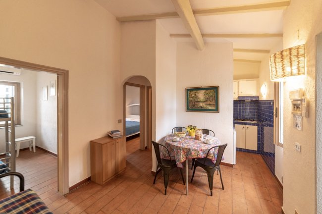 Interno con tavolo rotondo e cucina.