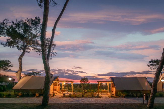 Bungalow al tramonto circondati da alberi.