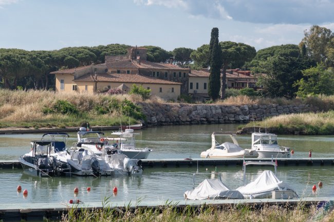 Barche attraccate in un porto con edifici sullo sfondo.