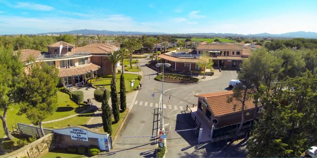 Vista aerea di un complesso residenziale con vialetti e alberi.