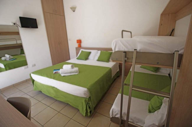 Camera con letto matrimoniale, letto a castello e TV a parete.