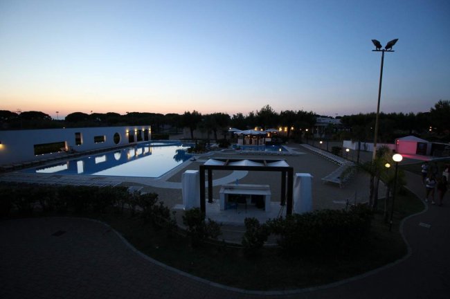 Piscina illuminata al tramonto.
