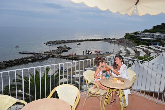 Due persone a tavola con vista sul mare.
