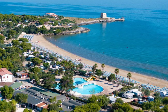 Piscina e spiaggia affollate.