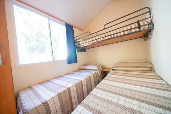 Camera con due letti singoli e un letto a castello.