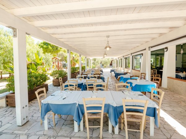 Veranda con tavoli apparecchiati all'aperto.