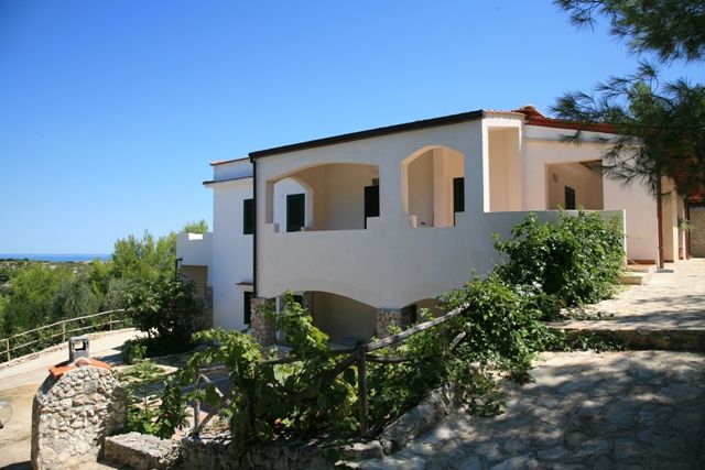 Villa bianca immersa nel verde con terrazza e vista.