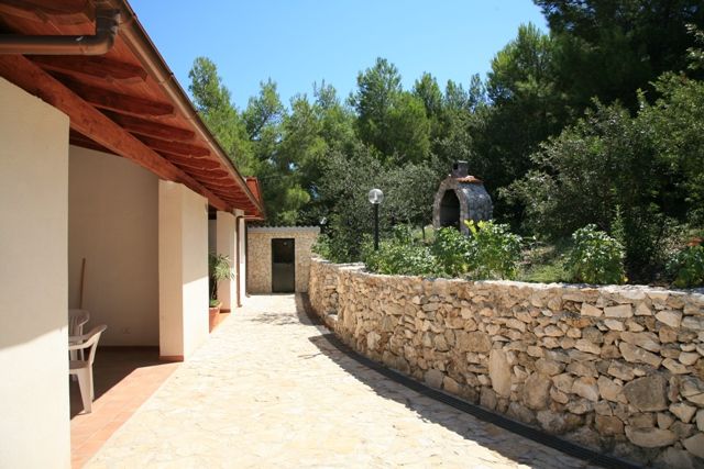 Un patio con mura in pietra e vegetazione.