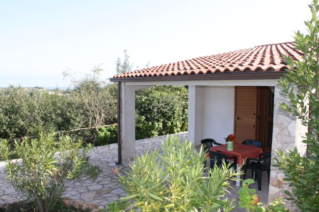 Patio con tetto rosso e tavolo all'aperto.