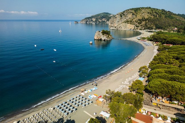 Spiaggia con ombrelloni e mare calmo.