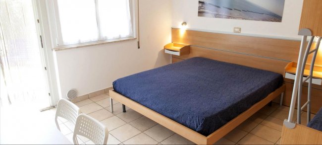 Camera con letto matrimoniale e arredamento moderno.