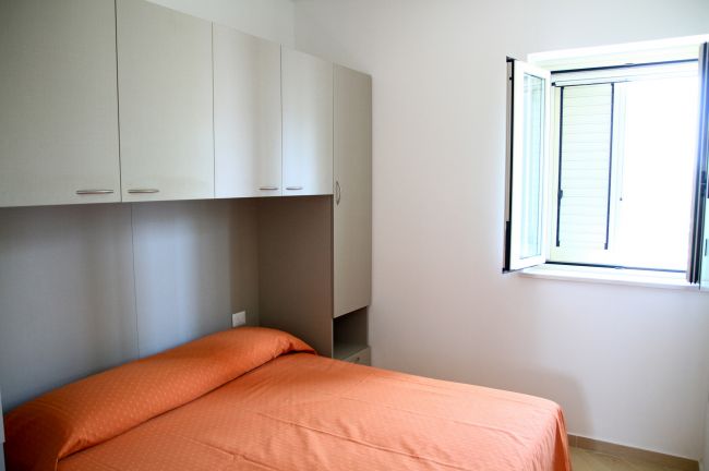 Camera da letto con letto arancione e armadio.