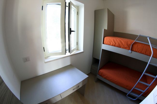 Cameretta con letto a castello e scrivania.