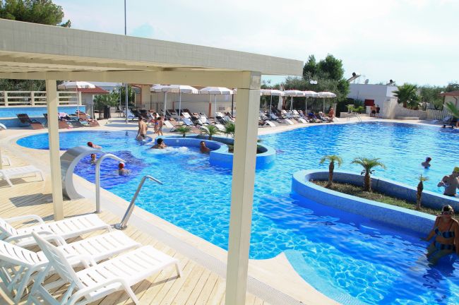 Piscina con area relax e lettini.
