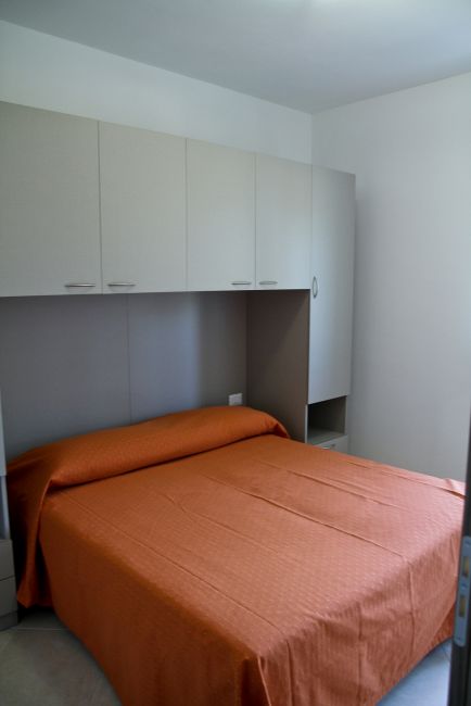 Camera da letto con letto matrimoniale e armadio a ponte.