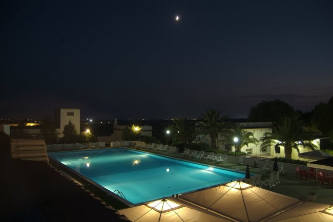 Piscina illuminata di notte vista dall'alto.