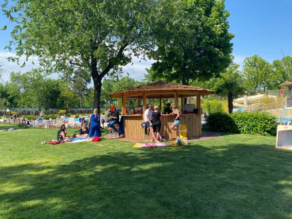 Persone riunite attorno a un chiosco nel parco.