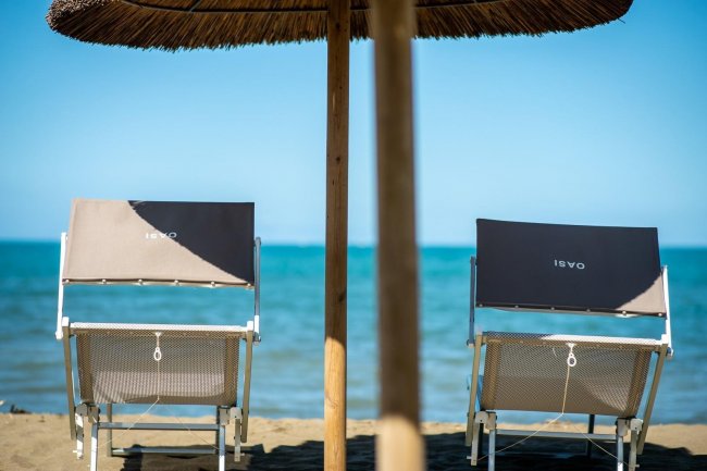 Due lettini sotto un ombrellone fronte mare.