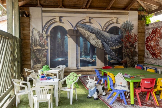 Zona giochi bimbi con murale di balena.