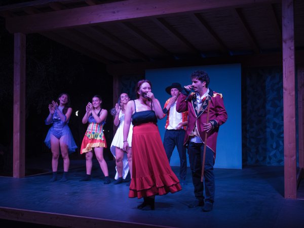 Performance di gruppo su un palco di legno.